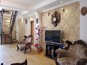 a living room with a television and two chairs at Hilltop Mestia in Mestia