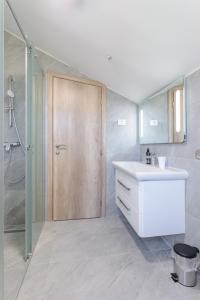 a bathroom with a sink and a shower and a door at CITY VIEW APARTMENT in Sutivan