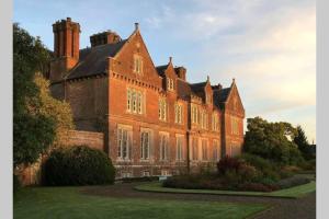 un gran edificio de ladrillo con muchas ventanas en The Gardeners Cottage at Wells House, en Glenranny