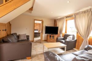 a living room with two couches and a tv at Mill Cottage 2 - Ash Farm Cotswolds in Stow on the Wold