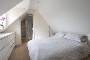 a white bedroom with a bed and a staircase at Mill Cottage 2 - Ash Farm Cotswolds in Stow on the Wold