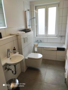 a bathroom with a toilet and a sink and a tub at Ferienwohnungen Wilhelmshöher Allee in Kassel