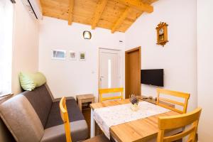 ein Wohnzimmer mit einem Tisch und einem Sofa in der Unterkunft Apartman Sabljak-Nerezine in Mali Lošinj