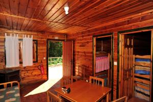 Cabaña de madera con mesa de madera y habitación en Cabañas La Toma del Agua en Riópar