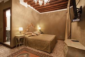 a bedroom with a bed and a table and a mirror at Hotel Al Ponte Mocenigo in Venice