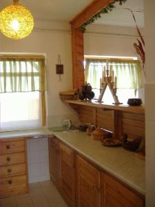 a kitchen with a counter and a sink and a mirror at Anna Üdülőház in Balatonberény