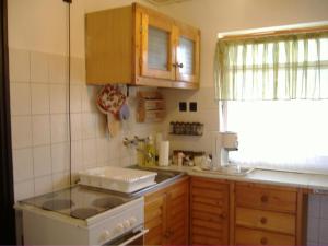 a kitchen with a stove and a sink and a window at Anna Üdülőház in Balatonberény