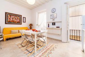 - un salon avec une table et un canapé jaune dans l'établissement Alojamientos Cadiz Sol, à Cadix