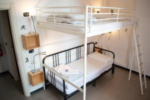 a room with two bunk beds and a ladder at Abbey Hostel in Genoa