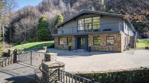 a large house with a driveway and a fence at Tholt-y-Will B&B in Sulby