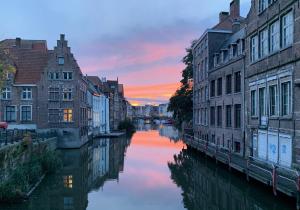 a view of a river in a city at sunset at Heaven AT 11, your Deluxe Studio with personal bathroom, kitchenette & terrace in Ghent
