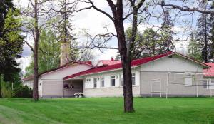 a white house with a red roof in a yard at Kartanomajoitus Sofia & Angelique in Pieksamaki