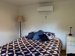 a bedroom with a bed with blue pillows at Mascot Cottage - Pet Friendly and Complimentary Breakfast Hamper in West Wyalong