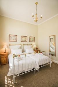 sypialnia z 2 białymi łóżkami i lustrem w obiekcie 54 on Middle - Solar-powered stay w mieście Graaff-Reinet