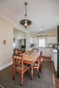 a kitchen with a wooden dining table and chairs at 54 on Middle - Solar-powered stay in Graaff-Reinet