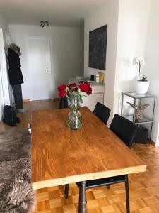 a dining room table with a vase of flowers on it at Charmantes Apartment in Bern