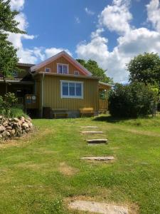 a yellow house with a pathway in front of it at STF Lugnåsberget Ekohotell in Mariestad