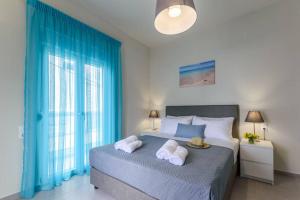 a bedroom with a large bed with blue drapes at Seashell Apt 2 in Stalida