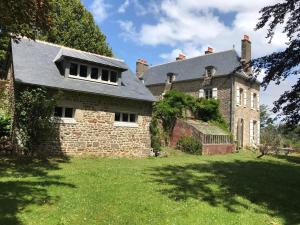 an old brick house with a roof on a yard at Le Prieuré Saint-Malo de Dinan in Dinan