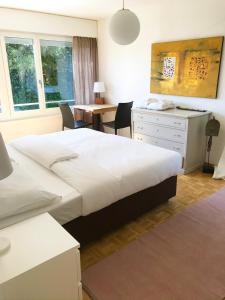 een slaapkamer met een groot bed, een bureau en een tafel bij Charmantes Apartment in Bern
