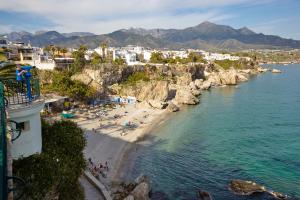 an aerial view of a beach with people in the water at Charming Nerja Hostel in Nerja