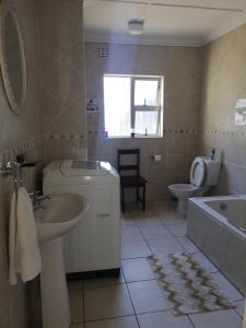 een badkamer met een wastafel, een toilet en een bad bij Mackenzies Accommodation in East London