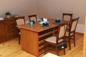 mesa de madera con sillas y comedor en Apartament Kaszubska Sielanka, en Kartuzy