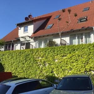 ein Gebäude mit einer grünen Hecke vor einem Auto in der Unterkunft Apartment Jessica in Mainz