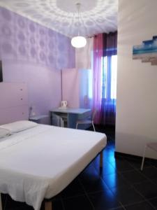 a bedroom with a white bed and a table at Affittacamere Sardegna Sole e Mare in Alghero