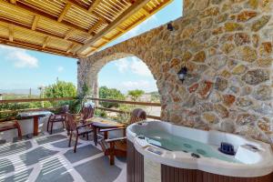 a bath tub on a patio with a stone wall at Limeri Traditional Guest House in Monólithos