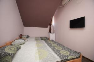 a bedroom with two beds and a flat screen tv at Apartmani Genčić 3 in Kladovo +8 photos