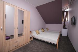 a bedroom with a bed and a wooden cabinet at Apartmani Genčić 3 in Kladovo