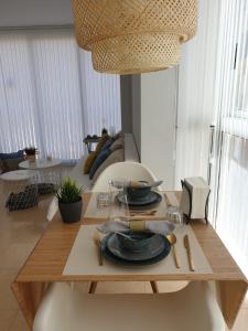 a wooden table with plates on it in a living room at Encantador apartamento junto al Mediterraneo by Hometels in Puerto de Sagunto