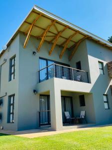 ein Haus mit einem Balkon mit Stühlen darauf in der Unterkunft Letaba Junction Lodge in Letsitele