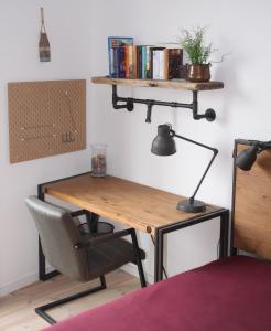 einen Schreibtisch mit einem Stuhl, einer Lampe und Büchern in der Unterkunft Mein Speicher-Platz in Barth
