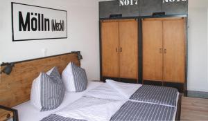 Schlafzimmer mit einem Bett mit einem Kopfteil aus Holz in der Unterkunft Mein Speicher-Platz in Barth
