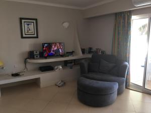 a living room with a chair and a television at Vale Do Lobo 935 in Loulé +12 photos