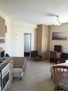 a kitchen and living room with a couch and a table at Olimpus Garden Homes in Ayia Napa