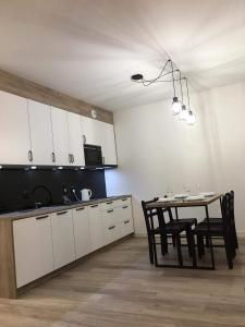 cocina con mesa y comedor en Apartament Kora en Kołobrzeg