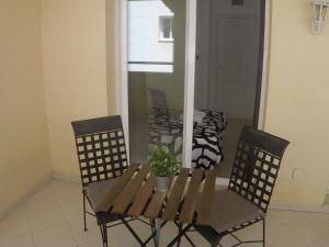 uma mesa de jantar e cadeiras com um vaso de plantas em Bonita y moderna habitación a 300m de la playa em Benalmádena