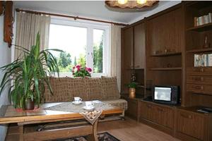 sala de estar con sofá, mesa y ventana en Willa Biała Dolina, en Szklarska Poręba