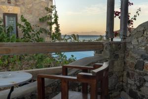 a table and chairs on a balcony with a view of the ocean at Alexandros by the Beach - Serifos in Livadakia