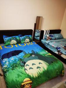 1 dormitorio con 2 camas y una gran manta de bienvenida en Bidor Totoro and One piece animation house, en Kampong Kuala Gepal