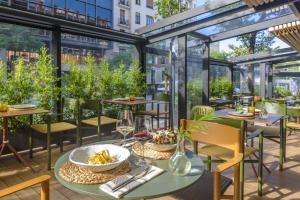 an outdoor patio with tables and chairs and windows at Melia Madrid Serrano in Madrid