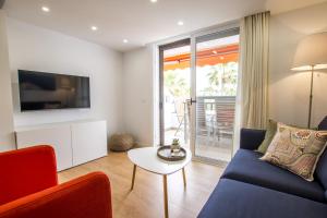 a living room with a blue couch and a tv at Parque Santiago 1 Duplex 2A014 in Playa de las Americas