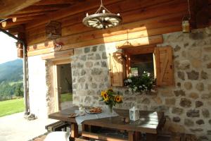 - une cuisine avec une table et un mur en pierre dans l'établissement BAITA NONNO GHINO, à Bedollo