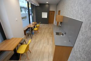 un restaurante con mesas y sillas amarillas en una habitación en dpaso Urban Hostel, en Pontevedra