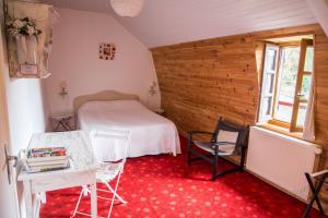 a bedroom with a bed and a table and chairs at Chambres d'hôtes de charme Le Pradel in Monceaux-sur-Dordogne