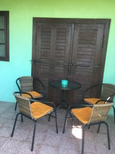 four chairs and a table with a table and a door at Village Wine House in Mandičevac