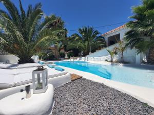 a swimming pool with white lounge chairs next to a house at Villa Adriano in Sabina Alta